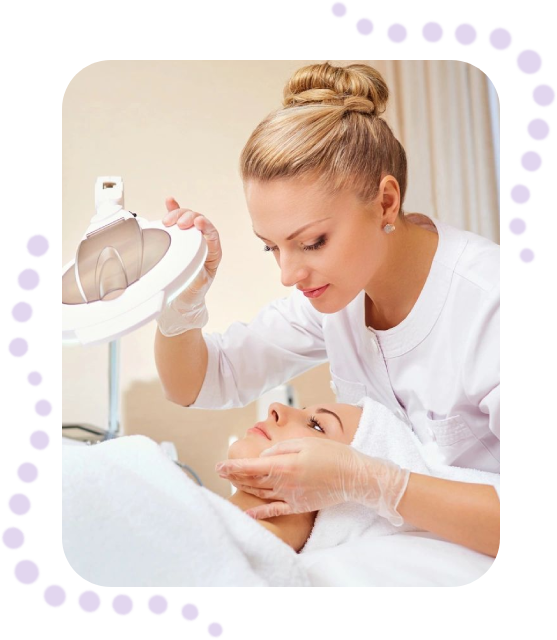 A woman is sitting down and putting something on her face.